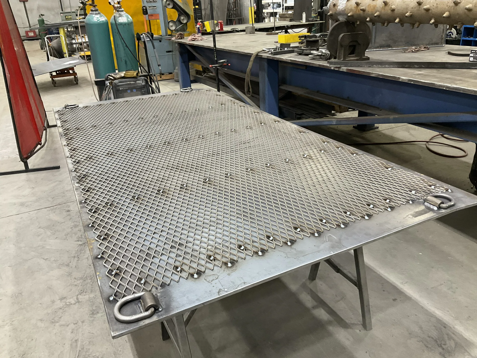 Expanded metal and D-rings welded to a fabricated steel plate assembly