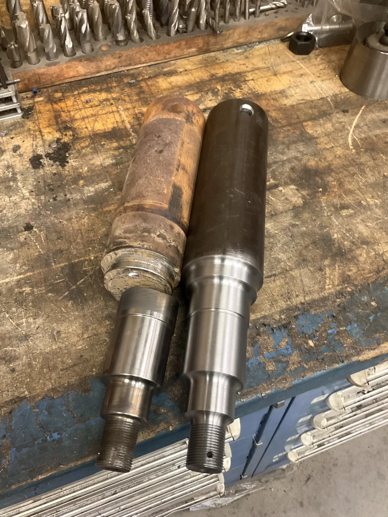 Worn component beside a machined replacement shaft in the Barnes machine shop